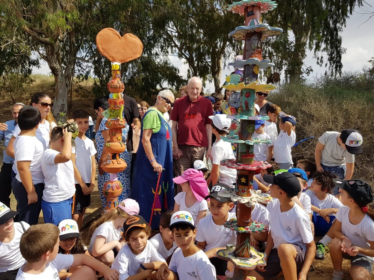 בצילום- הזוג ויינטרוב עם תלמידים ועמודי הטוטם.