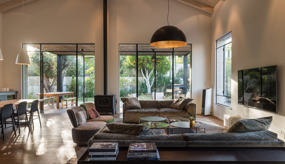 החלל הציבורי שבקומת הכניסה נפרש כלופט גבה תקרה, ללא מחיצות המפרידות בין אזוריו השונים. שפת העיצוב אקלקטית ומושתתת על ניגודים משלימים. צילום: גלעד רדט