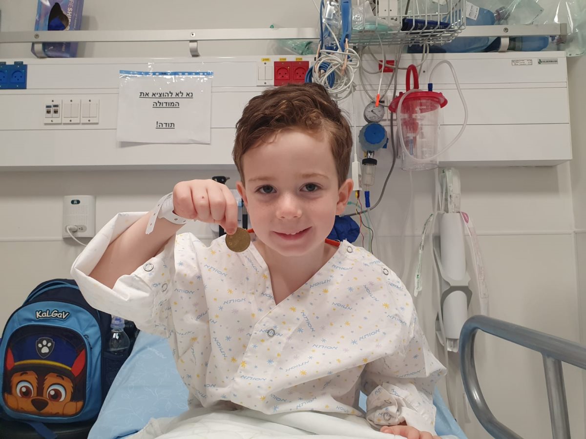 עידן בן ה-5 והמטבע שחולץ מגרונו. צילום: דוברות בית החולים