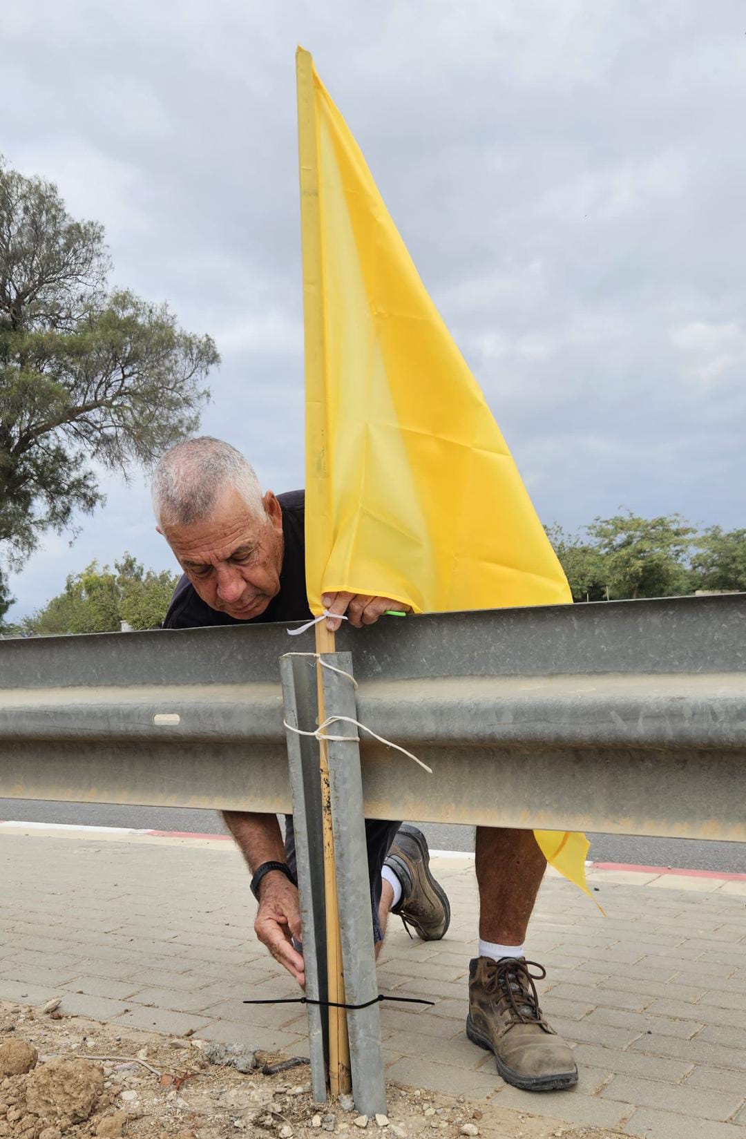 אודי ברמק תולה הבוקר דגלים צהובים בכבישי העוטף. קרדיט: מור סיימונס